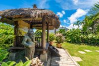 a small hut with a statue in a garden at Red Garden Resort in Eluan