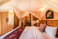 a bedroom with a large bed with a canopy at Red Garden Resort in Eluan