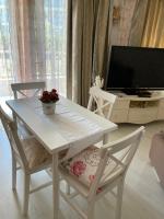 a white table and chairs in a living room with a tv at SPA Apartament Sirius house in Saints Constantine and Helena