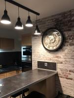 une grande horloge sur un mur de briques dans une cuisine dans l&#39;établissement la licorne { T2 tous confort} centre ville, à Pont-Audemer