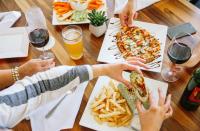 a group of people sitting around a table eating food at Hotel Indigo Orange Beach - Gulf Shores by IHG in Gulf Shores