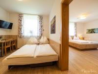 a hotel room with two beds and a dining room at Pension Ehrenfried - Hotel garni in Kindberg