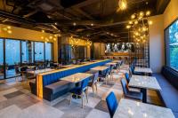 チレゴンにあるAston Cilegon Boutique Hotelのテーブルと椅子と窓のあるレストラン