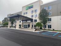 Un edificio de oficinas con un estacionamiento enfrente. en Holiday Inn Express Wixom by IHG, en Wixom