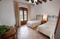 a bedroom with two beds and a table and a window at Hostal El Cortijo in Algodonales