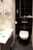 a bathroom with a white toilet and a sink at Hôtel La Sanguine in Paris