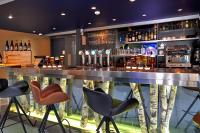 a bar with chairs and a counter with liquor bottles at Kyriad La Roche Sur Yon in La Roche-sur-Yon