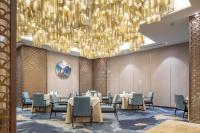 西安市にあるグラン メリア 西安のダイニングルーム(シャンデリアの下にテーブルと椅子付)