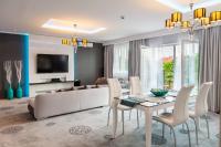 Una sala de estar con un sofá blanco y una mesa. en Hotel Mikulski, en Gliwice