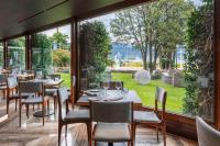 a restaurant with tables and chairs and a large window at Hotel La Palma in Stresa