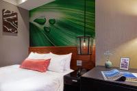 a bedroom with a bed with a painting on the wall at Pacific Business Hotel in Taipei