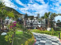 a view of an rv park with a patio and flowers at Tudor Dynasty Homestay in Yanliau