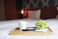 a tray with a coffee cup and flowers on a bed at Talmud Hotel Yizhong in Taichung