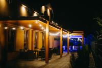 eine Terrasse am Abend mit einem Tisch und Stühlen in der Unterkunft Szelesiówka & SPA in Chodzież