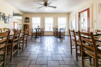 een eetkamer met tafels en stoelen en ramen bij The Babcock House in Appomattox