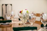 een tafel met glazen en een vaas met bloemen erin bij The Babcock House in Appomattox