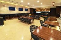 Un restaurante con mesas y sillas de madera y un bar. en Holiday Inn & Suites - Puerto Vallarta Marina & Golf by IHG, en Puerto Vallarta