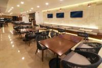 Un restaurante con mesas y sillas de madera en una sala. en Holiday Inn & Suites - Puerto Vallarta Marina & Golf by IHG, en Puerto Vallarta