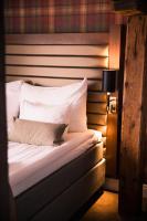 Una cama con sábanas blancas y almohadas en una habitación. en Home Hotel Packhuset, en Kalmar
