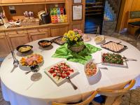 una mesa blanca con tazones de comida. en Gasthof Trausberg, en Corvara in Passiria