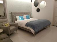 a bed with blue pillows and a chair in a room at HL53 B&amp;B in Hualien City