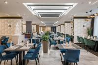 シャーロシュパタクにあるHotel Bodrog Wellness & Elix Spaのダイニングルーム(テーブル、青い椅子付)