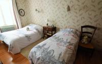 a bedroom with two beds and a teddy bear at La Maison des Chats in Saint-Mary-le-Plain