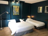 two beds in a room with blue walls at Logis Hôtel l&#39;Abricotine in Tain-lʼHermitage