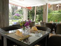 Una mesa en un restaurante con una mesa puesta con flores. en Iris Hotel, en Toubab Dialaw
