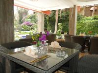 una mesa en un restaurante con sillas y flores. en Iris Hotel, en Toubab Dialaw