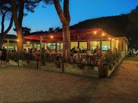 a restaurant with people sitting inside of it at night at Campeggio del Forte in Marina di Bibbona