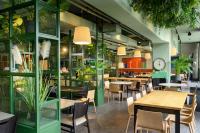 Un restaurante con mesas, sillas y plantas. en Hotel Sport - Terme Krka, en Otočec