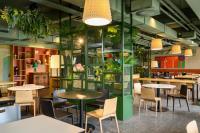 Un restaurante con mesas, sillas y plantas. en Hotel Sport - Terme Krka, en Otočec