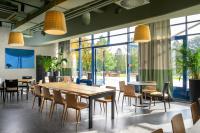 Un restaurante con mesas y sillas y grandes ventanales. en Hotel Sport - Terme Krka, en Otočec