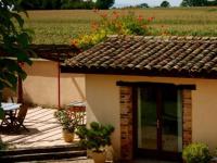 a small house with a patio with a table and chairs at Les Barelles in Saint-Jean-de-Thurigneux