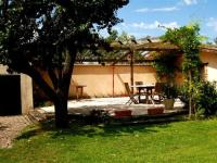 a patio with a table in a yard at Les Barelles in Saint-Jean-de-Thurigneux