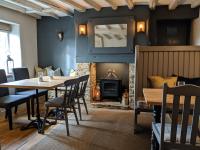 Quenington守护者臂弯宾馆的带桌子和壁炉的餐厅