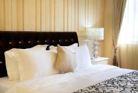 a bed with white pillows and a black head board at Miller Home in Yuchi