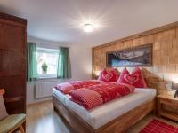 a bedroom with a bed with red pillows on it at s´Brunnhäusl in Kelchsau