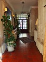 a hallway with plants and a door in a house at Au Saint Roch - Hôtel et Jardin in Avignon