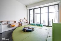 a living room with a couch in a room with windows at Taitung Spring Homestay B&amp;B in Taitung City