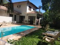 a villa with a swimming pool in front of a house at Pousada Falls Park in Foz do Iguaçu