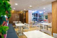 a restaurant with white tables and chairs and shelves at Paradise Park Fun Lifestyle Hotel in Los Cristianos