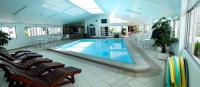Una gran piscina en un edificio con sillas. en Hotel Jaragua, en Joaçaba