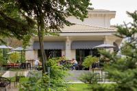 Menschen sitzen an Tischen vor einem Gebäude in der Unterkunft Primorski Hotel in Sweti Konstantin