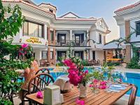 una casa con piscina y una mesa con flores en Dalyan Hotel Nish Caria, en Dalyan