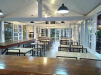 una sala da pranzo con tavoli, sedie e finestre di Hotel Pousada Casacolina a Búzios