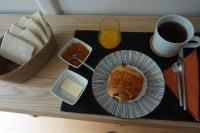 a table with a plate of food and a glass of orange juice at Le calme à 2 pas de Paris in Levallois-Perret