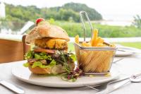 ポート・エドワードにあるThe Estuary Hotel & Spaのサンドイッチとフライドポテトをテーブルに乗せた皿