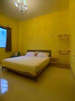 a bedroom with a bed with yellow walls and a chandelier at EZE Homestay in Ji&#39;an